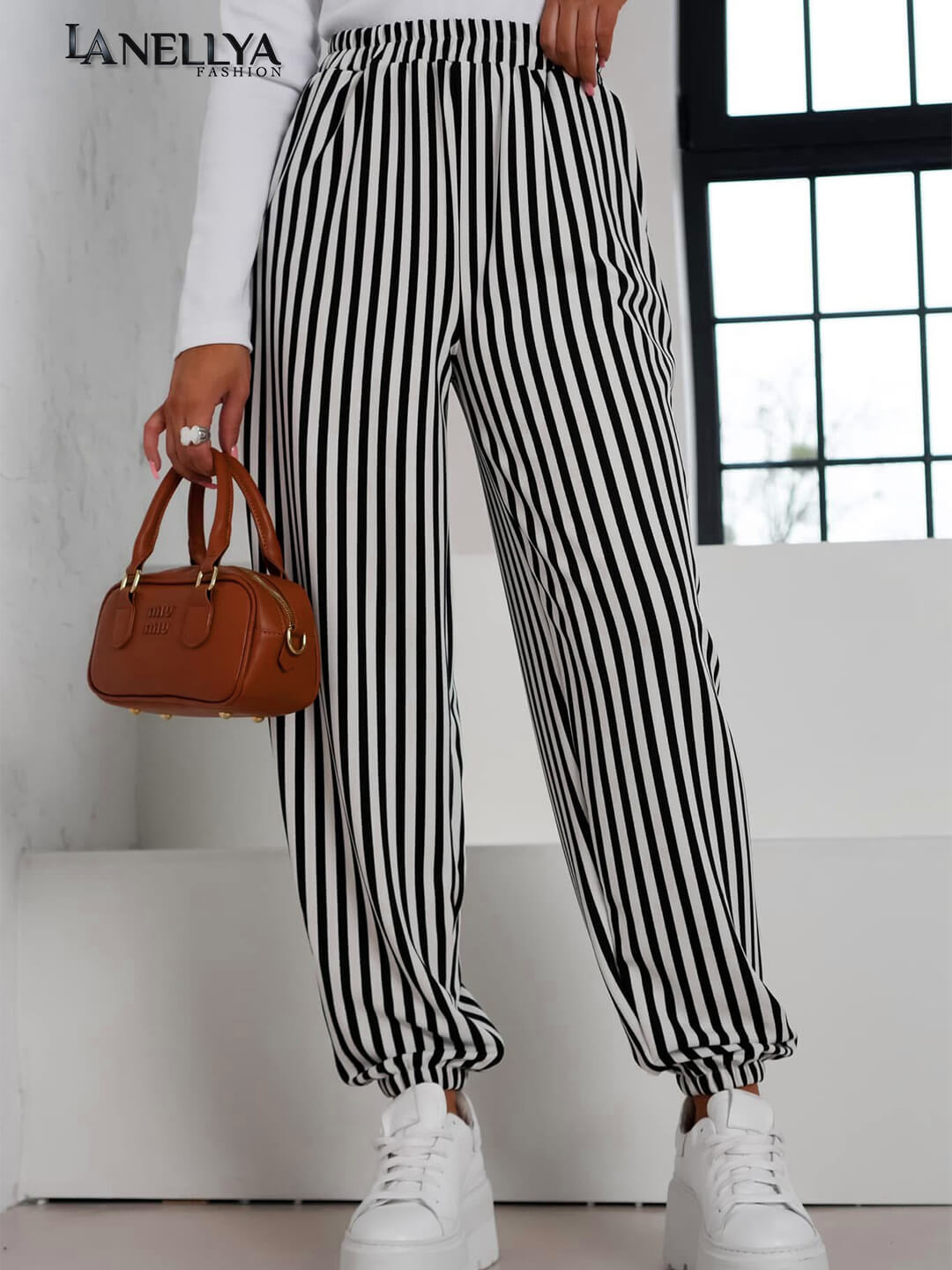 Model trägt Laki Couture Hose mit Streifen kombiniert mit weißem Longsleeve